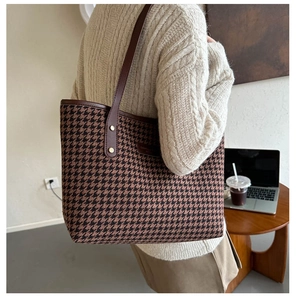 Classic houndstooth tote bag with dark brown leather straps shown in a cafe setting