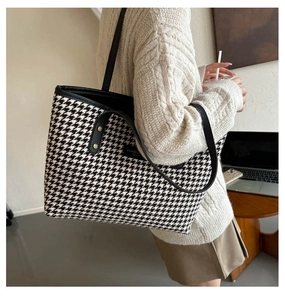Close-up of the houndstooth pattern fabric and black leather strap on the tote bag