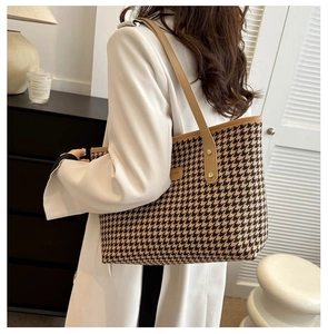 Dettaglio della borsa tote pied-de-poule con tracolla in pelle cammello e borchie in metallo
