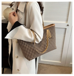 Dettaglio della borsa shopper pied-de-poule con manici in pelle e rivetti metallici