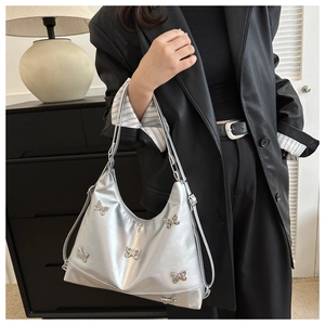 Detail der silbernen Metallic-Hobo-Tasche mit funkelnden Strass-Schmetterlings-Verzierungen