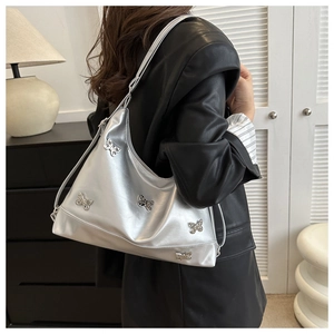 Details einer silbernen Metallic-Hobo-Tasche mit fünf dekorativen Schmetterlingen aus Metall