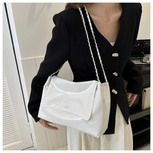 Détail du sac cabas blanc brillant avec bandoulière chaîne et lettrage élégant