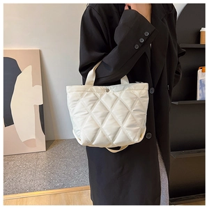 Détail du sac seau matelassé blanc en nylon brillant avec fermeture à bouton-pression en métal