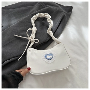 Détail du sac demi-lune blanc avec patch lapin coeur et bandoulière plissée stylée