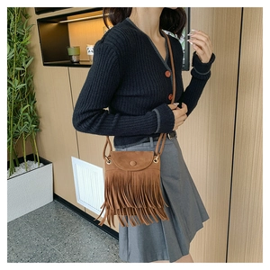 Détail du sac à bandoulière en daim marron avec franges et rabat style bohème