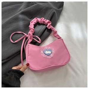 Détail du sac en nylon rose avec écusson cœur lapin et bandoulière froncée