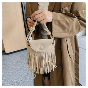 Détail du sac bandoulière en daim beige avec franges bohèmes et fermeture à rabat
