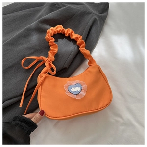 Détail de l'écusson de lapin en forme de cœur et de la bandoulière à volants du sac