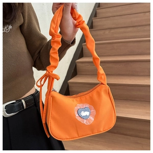 Détail du sac orange avec poignée plissée nuage et décoration patch lapin et cœur