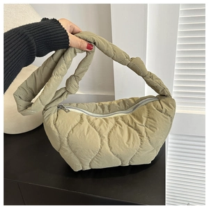 Detail showing wavy quilted texture and zipper closure on olive green shoulder bag