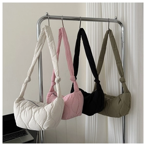 Detailed row of quilted puffer underarm bags in cream, pink, black, and olive green colors