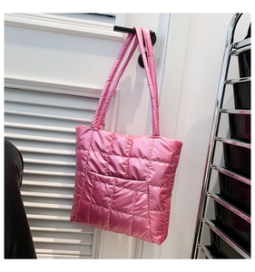 Detail of bright pink quilted tote bag showing square stitching and outer pocket