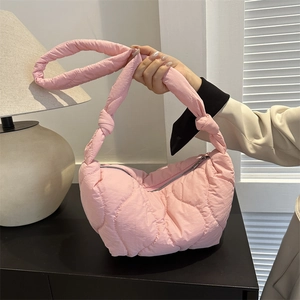 Pink quilted dumpling underarm bag with knotted strap and wavy padded texture