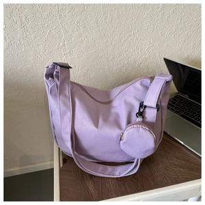 Detail of light purple crescent canvas crossbody bag with textured grid and mini coin purse