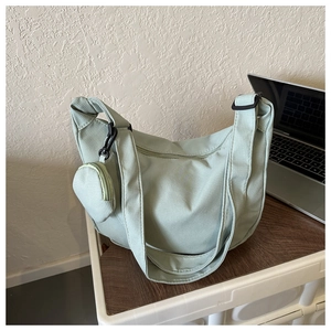 Detail of light green crescent shoulder bag with detachable small round coin purse