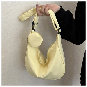 Detail of light yellow crescent shoulder bag with adjustable strap and coin purse