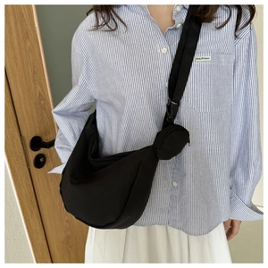 Detail of black nylon crescent crossbody bag with adjustable strap and small coin pouch