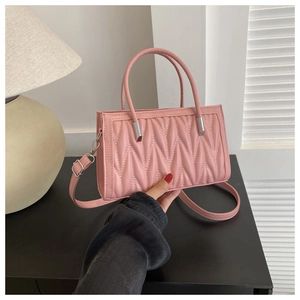 Dettaglio della borsa rosa matelassé con doppi manici e ganci in metallo argento