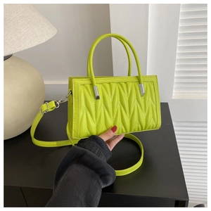 Dettaglio della borsa trapuntata verde lime con cuciture a V e tracolla in pelle
