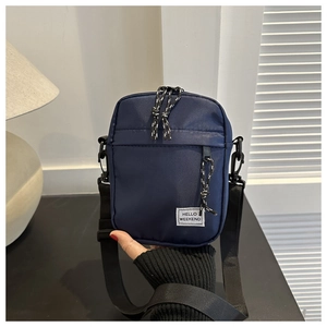Close-up of navy blue oxford fabric crossbody bag with Hello Weekend label and zipper