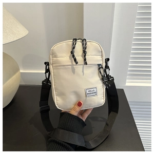 Close-up of off-white Oxford fabric phone bag with adjustable strap and HELLO WEEKEND patch