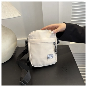 Close-up of off-white nylon crossbody phone bag with Hello Weekend woven label