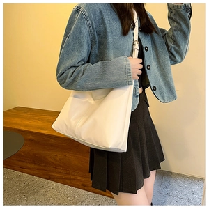 Detail of white large capacity tote bag with vertical stitching and slim shoulder strap