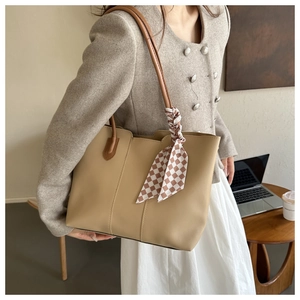Detail of khaki tote bag with textured faux leather and checkered silk scarf accent