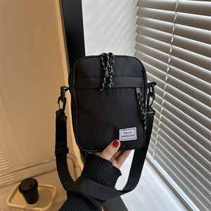 Black nylon crossbody bag with HELLO WEEKEND label and adjustable shoulder strap