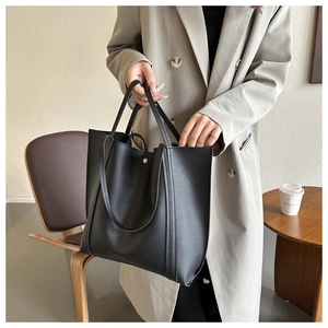 Close-up of black PU leather tote bag showing fine texture and large capacity for commuting