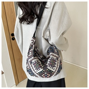 Detail of bohemian knit crossbody bag with ethnic patterns and black nylon shoulder strap