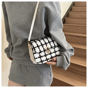 Classic black and white checkered tweed crossbody bag with golden buckle on model