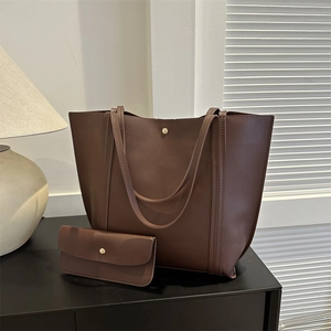 Minimalist dark brown leather tote bag with small matching pouch and gold button detail