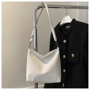 Detail of white pebble grain leather bucket bag with silver metal buckle on strap