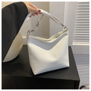 Detail of white lychee leather tote bag featuring adjustable strap and silver metal hardware