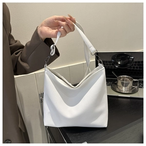 Detail of white lychee grain leather handbag with matte gunmetal hardware and strap