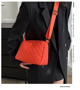 Fashionable bright orange quilted crossbody bag with adjustable wide shoulder strap detail