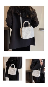 Detailed close-up showing the elegant diamond quilted texture of the white crossbody bag