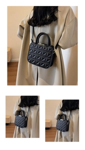 Detail of black quilted crossbody bag with gold hardware and adjustable strap