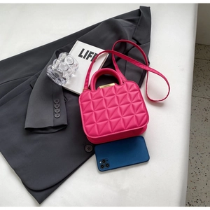 Top view of fuchsia quilted handbag with gold hardware and shoulder strap details