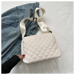 Detail of cream quilted crossbody bag with adjustable wide nylon shoulder strap