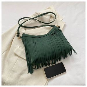 Close-up of dark green suede bucket bag with long tassels and gold metal hardware detail