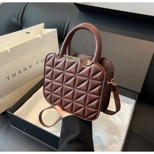 Deep brown quilted handbag with gold bar detail, gift box and thank you paper bag