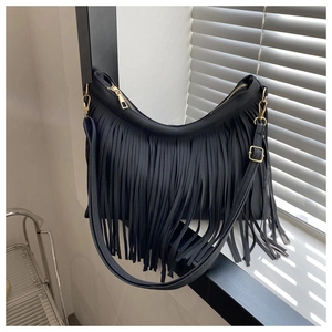 Close-up of black fringe shoulder bag with gold zipper and stylish shadow patterns