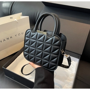 Quilted black handbag with gold metal bar in premium gift box packaging