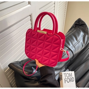Detail of rose red quilted PU leather handbag with golden hardware and adjustable strap