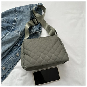 Detailed view of quilted rhombic crossbody bag in grey-green with wide nylon strap
