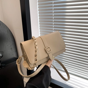 Bolso bandolera beige minimalista con asa tejida y detalle de correa decorativa con hebilla