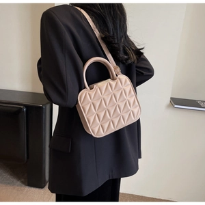 Chic beige quilted small square bag shown from a side perspective with shoulder strap